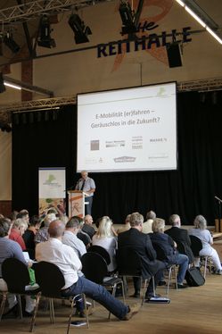 Der stellv. Bürgermeister Friedhelm Eggers begrüßt die rund 100 Teilnehmer von „E-Mobilität (er)fahren“ in der „Alten Reithallen“ in Soltau.